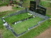 Graniidist hauapiire Tallinna Metsakalmistul, mitmekihiline, pealt poleeritud servad murtud, muruvaip